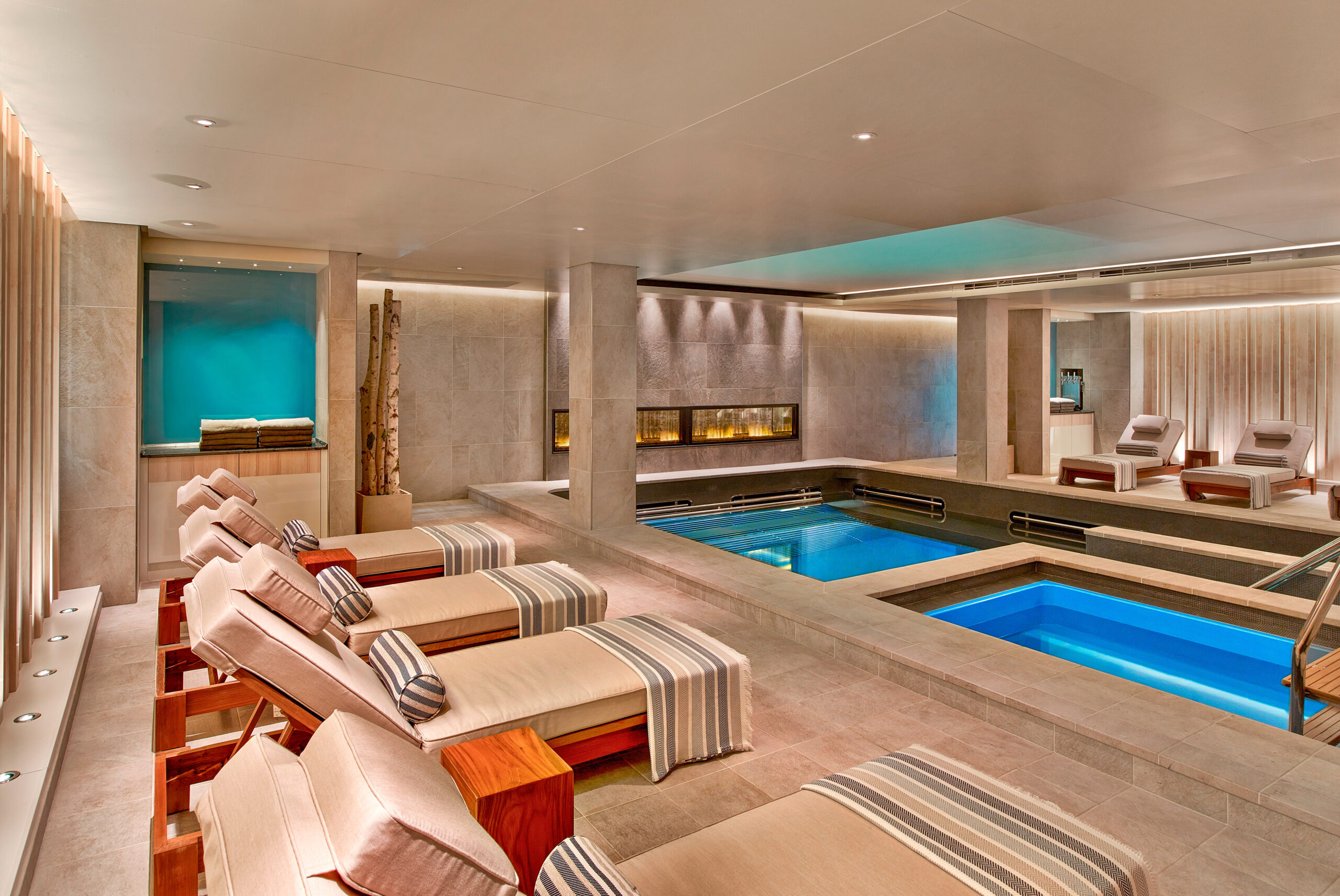 Lounge chairs and heated salt pools inside the Viking Sea LivNordic Spa and Wellness Center.